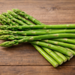 長野市場で仕入れられる新鮮なアスパラガス。鮮やかな緑色のアスパラが木のテーブルに並ぶ春野菜